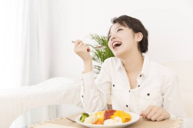 Güzel Japon kadın evde yemek yiyor.