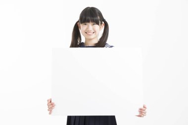 Okul üniformalı güzel bir öğrencinin portresi. Elinde beyaz bir tahta var.