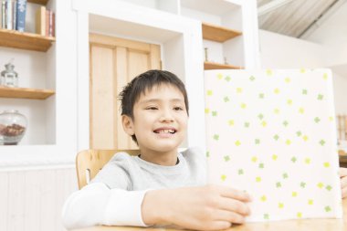 Asyalı küçük çocuk kitap okuyor.  