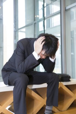 Başı ağrıyan genç Asyalı adam. 