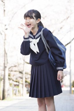 Sırt çantalı Asyalı kız parkta çığlık atıyor.