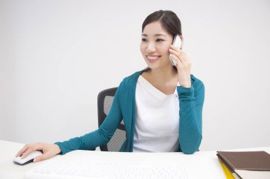 Ofiste cep telefonu kullanan bir kadın. 