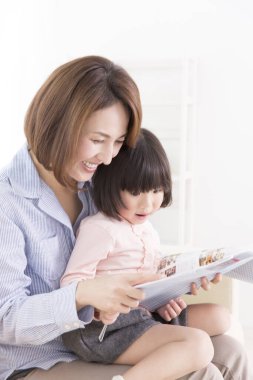 Asyalı anne-kız kitap okuyor. 