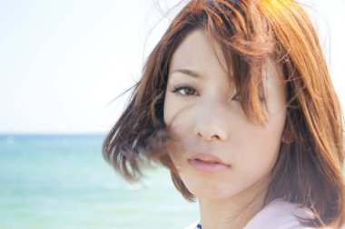 Sahilde poz veren Asyalı kız.