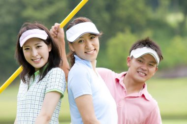 Mutlu Asyalı erkek ve kadın golfçüler