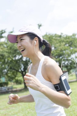 Parkta koşan Asyalı kadın.