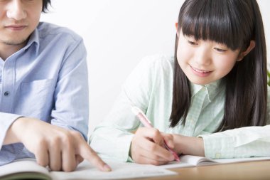 Evde babasıyla ödev yapan tatlı Asyalı kız.