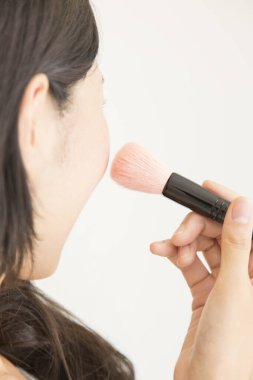 Kadın fırçayla makyaj yapıyor 