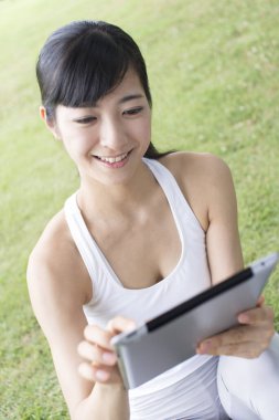 woman using a tablet in park 