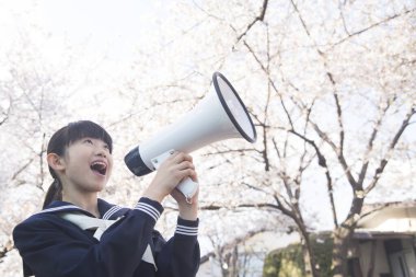 Sokaktaki hoparlörlü güzel Japon öğrencinin portresi.