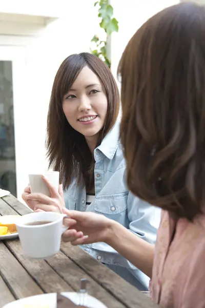 Bir kadın arkadaşıyla kahve içiyor.