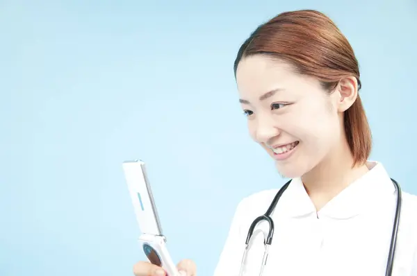 Портрет Красивой Молодой Японской Медсестры Форме Помощью Складного Телефона Синем — стоковое фото