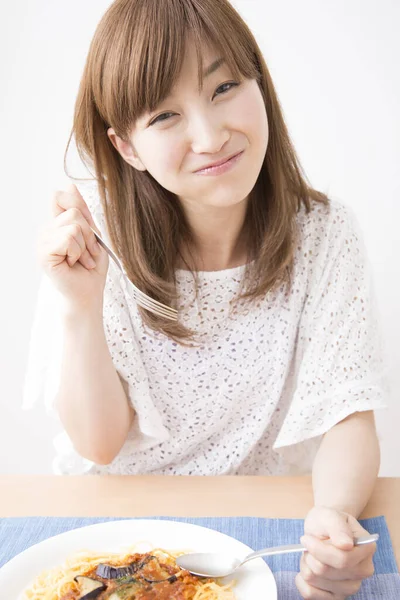 Genç Asyalı kadın erişte yiyor.