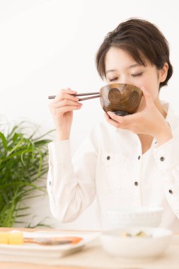 Güzel Japon kadın evde yemek yiyor.