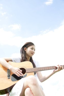 Gitarlı Asyalı genç kadın. 