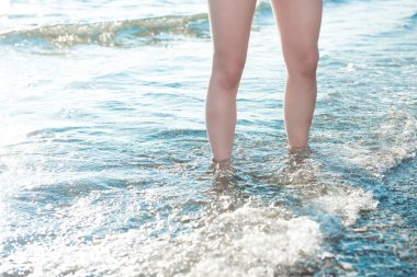 Sahilde suda duran bir kadın.