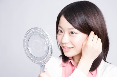 Aynaya bakan güzel bir kadının portresi, stüdyo fotoğrafı. 