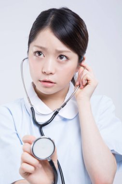 Beyaz üniformalı güzel Asyalı doktorun portresi.