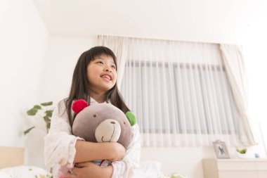 Küçük kız evde oyuncakla oynuyor.