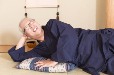 Olgun Asyalı adam yerde dinleniyor.