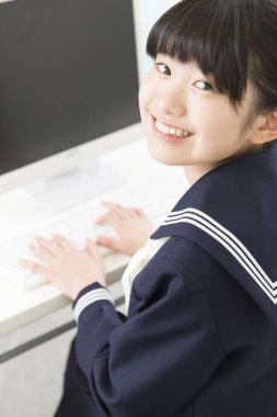 Okul üniforması içinde bilgisayar eğitimi alan güzel bir öğrencinin portresi.