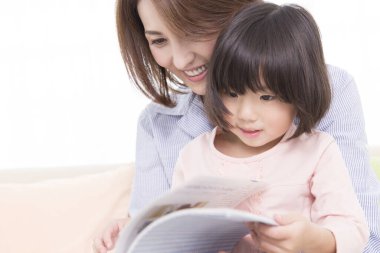 Asyalı anne-kız kitap okuyor. 