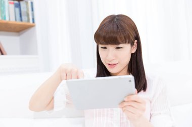 Tablet kullanan genç bir kadın.