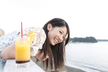 Sahilde meyve suyu içen kadın.