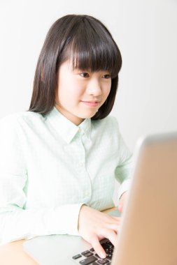 Evde dizüstü bilgisayar kullanan öğrenci kız.