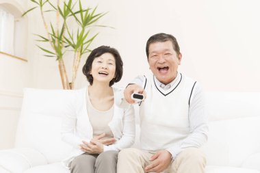 Kanepede oturan Asyalı çift.