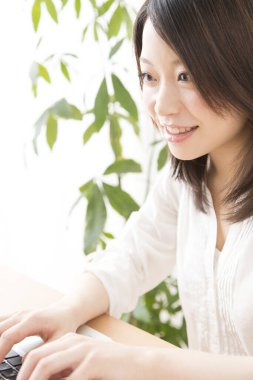 Evde dizüstü bilgisayarda çalışan Asyalı kadın.