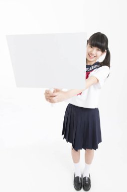 Okul üniformalı güzel bir öğrencinin portresi. Elinde beyaz bir tahta var.