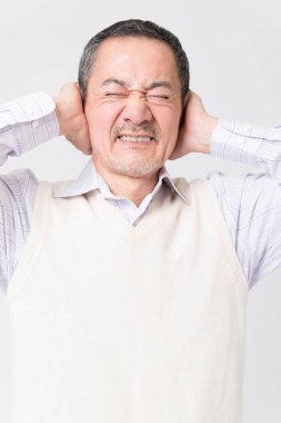 Beyaz arka planda acıdan muzdarip olgun Asyalı adamın portresi.