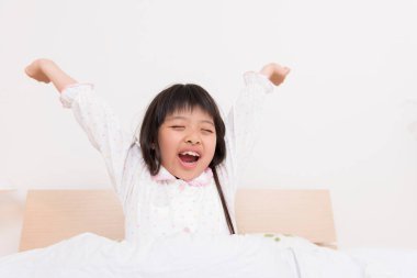 Elleri yatağında mutlu bir kız.