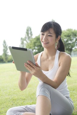 Genç Asyalı kadın ile tablet bilgisayar