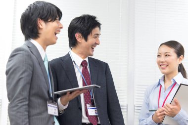 Ofiste gülümseyen Asyalı iş adamları