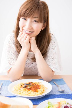Evde spagettisi olan güzel bir Japon kadın.