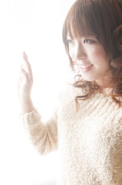 Genç Asyalı kadın pencereye bakıyor. 