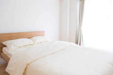 Beyaz çarşaflı ve yastıklı bir yatak. iç tasarım