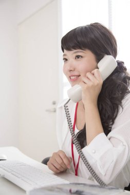 Genç Asyalı iş kadını ofiste çalışıyor.