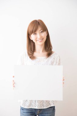 Genç Asyalı iş kadını elinde boş bir kart tutuyor.