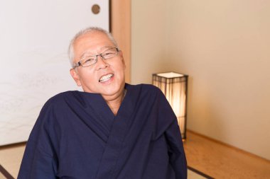 Olgun Asyalı adam yerde dinleniyor.