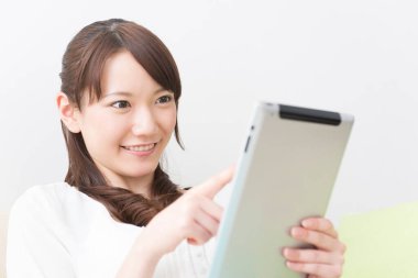 Asyalı kadın evde tablet kullanma