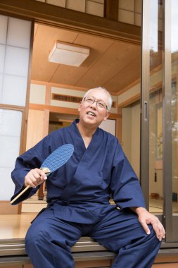 Tahta yelpazeli yaşlı bir Asyalı 'nın portresi.