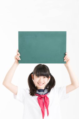 Okul üniformalı güzel genç bir öğrencinin portresi. Elinde yeşil boş bir tahta var.