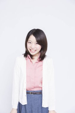 Beyaz arka planda gülümseyen genç bir kadın. 