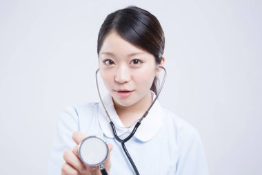 Beyaz üniformalı güzel Asyalı doktorun portresi.