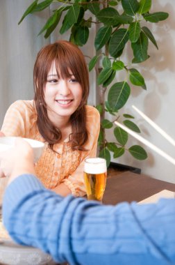 Masada içkilerle gülümseyen kadın.