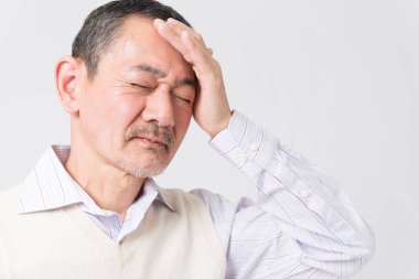 Beyaz arka planda acıdan muzdarip olgun Asyalı adamın portresi.