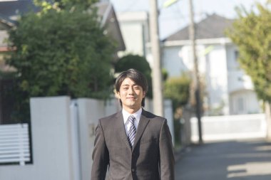 Genç Asyalı işadamı sokakta yürüyor 